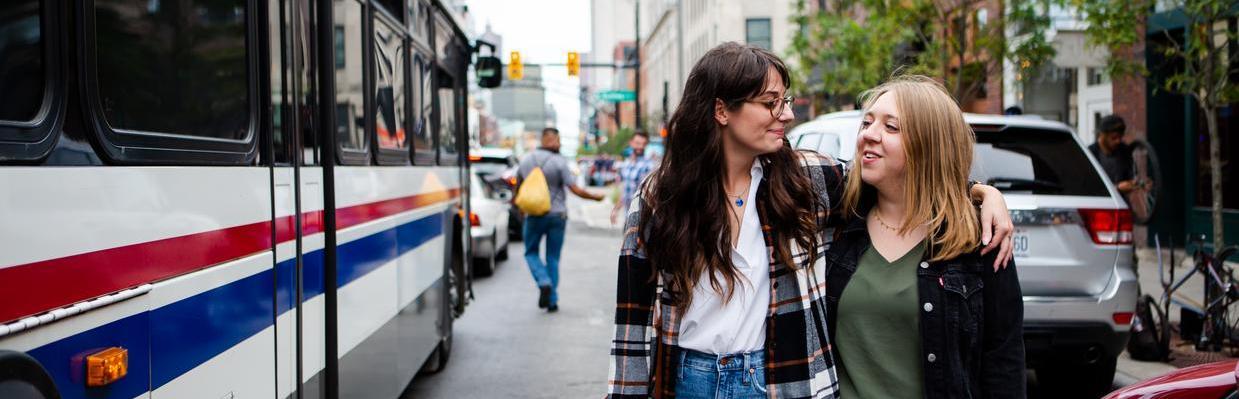 Two women walking by COTA bus