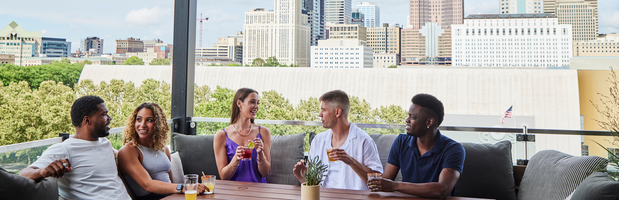 Group of friends enjoying drinks with Columbus skyline in background